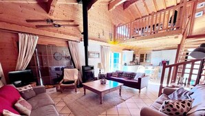 Una sala de estar acogedora con chimenea, un sofá, una mesa de centro y un comedor.
