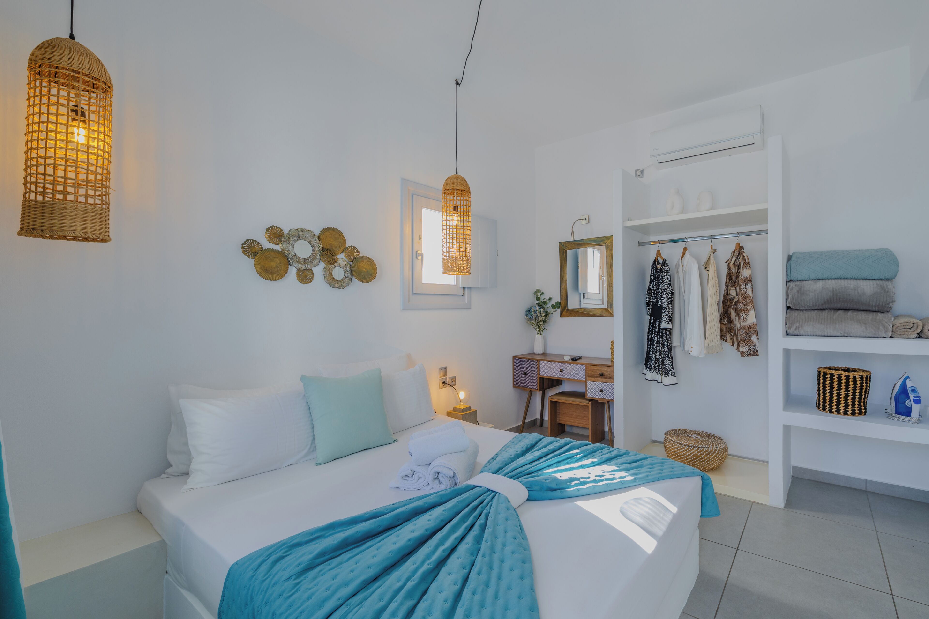 Un dormitorio con cama, mesita de noche, lámpara, armario y una lámpara colgante.