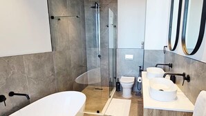 A modern bathroom with a glass-enclosed shower, a freestanding bathtub, a toilet, and a vanity with two sinks. - Luxury modern 3 bed Penthouse apartment in Green Point near V&A Waterfront, CBD (Cape Town)