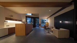 A modern hotel lobby with a reception desk, seating area, and large windows. - Shangri-La City Yunjian Songyue (Deqin)