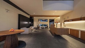 A modern hotel lobby with a reception desk, seating area, and a view of the street. - Shangri-La City Yunjian Songyue (Deqin)