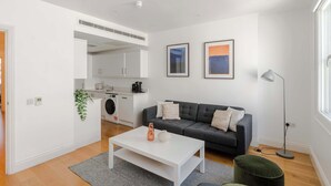 En moderne stue med sofa, sofabord og gulvlampe.