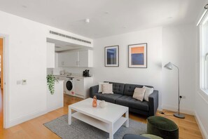 Ein modernes Wohnzimmer mit einer Couch, einem Couchtisch und einer Stehlampe.