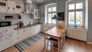 Una cucina moderna con mobili bianchi, un tavolo da pranzo in legno e un'ampia finestra con vista.