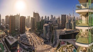 A cityscape with modern high-rise buildings, a prominent tower, and a circular road.
