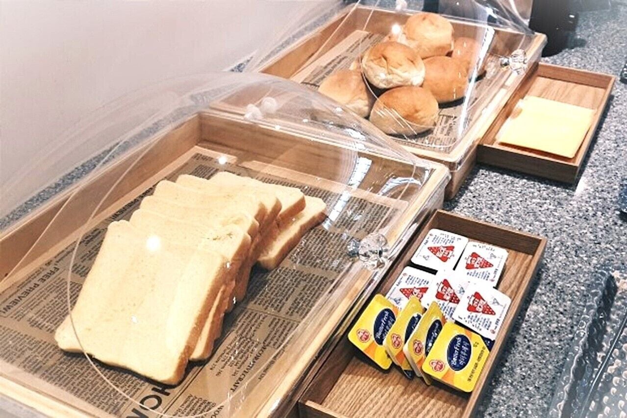 Ein Frühstücksbuffet mit Brot, Gebäck und Beilagen.