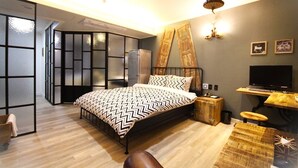 A modern bedroom with a bed, a desk, a television, and a wardrobe. - Heritage Hotel (Changwon)