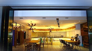 A modern kitchen with a dining area, featuring a central island, wooden chairs, and a patterned floor. - Heritage Hotel (Changwon)