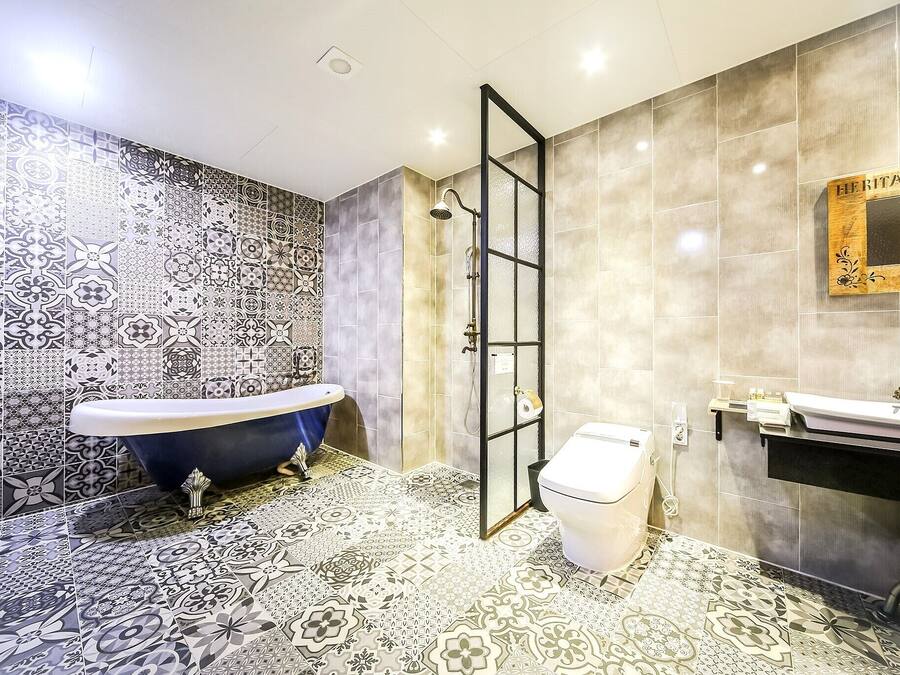 A bathroom with a freestanding bathtub, a shower, a toilet, and a sink.