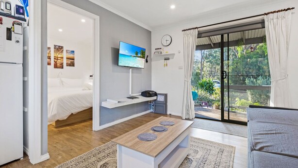 Habitació moderna amb llit, televisió, escriptori i vistes a l'exterior.