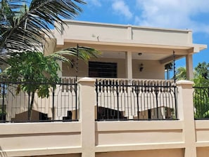 A two-story building with a balcony, a gated entrance, and a clear sky. - Mbweni Zanzibar Lux House (Zanzibar Town)
