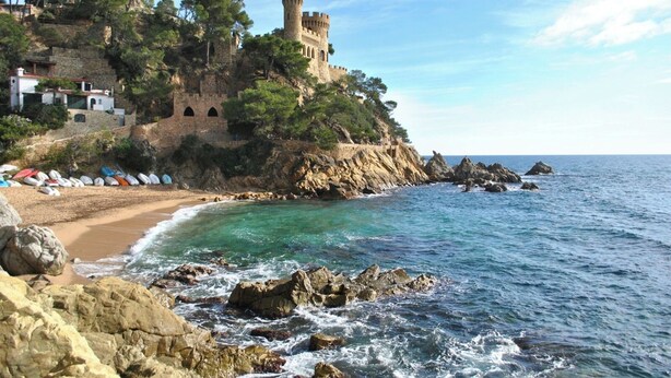 A coastal castle with a beach, rocky shoreline, and clear blue sea. - Fenals Family Apartment with Pool (Lloret de Mar)