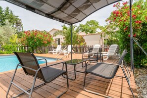A poolside area with lounge chairs, a table, and a pergola. - Cottage 'Gîte Chez Augustine' with Wi-Fi and Air Conditioning (Sarrians)