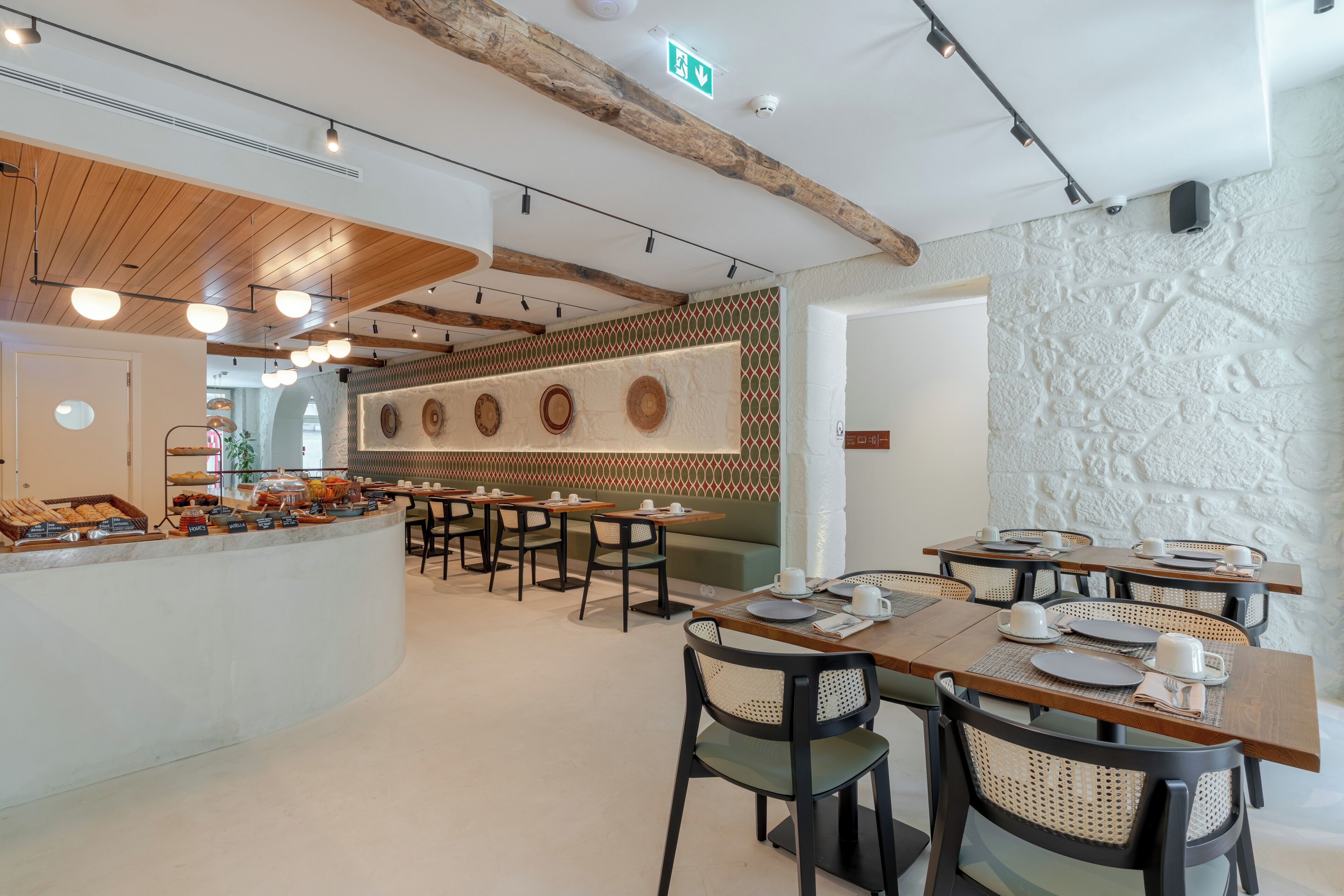 Un café moderne avec des tables en bois, des chaises noires et un comptoir de buffet.