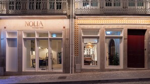 A boutique hotel with a modern interior, large windows, and a red door. - NOLIA Boutique Hotel (Porto)