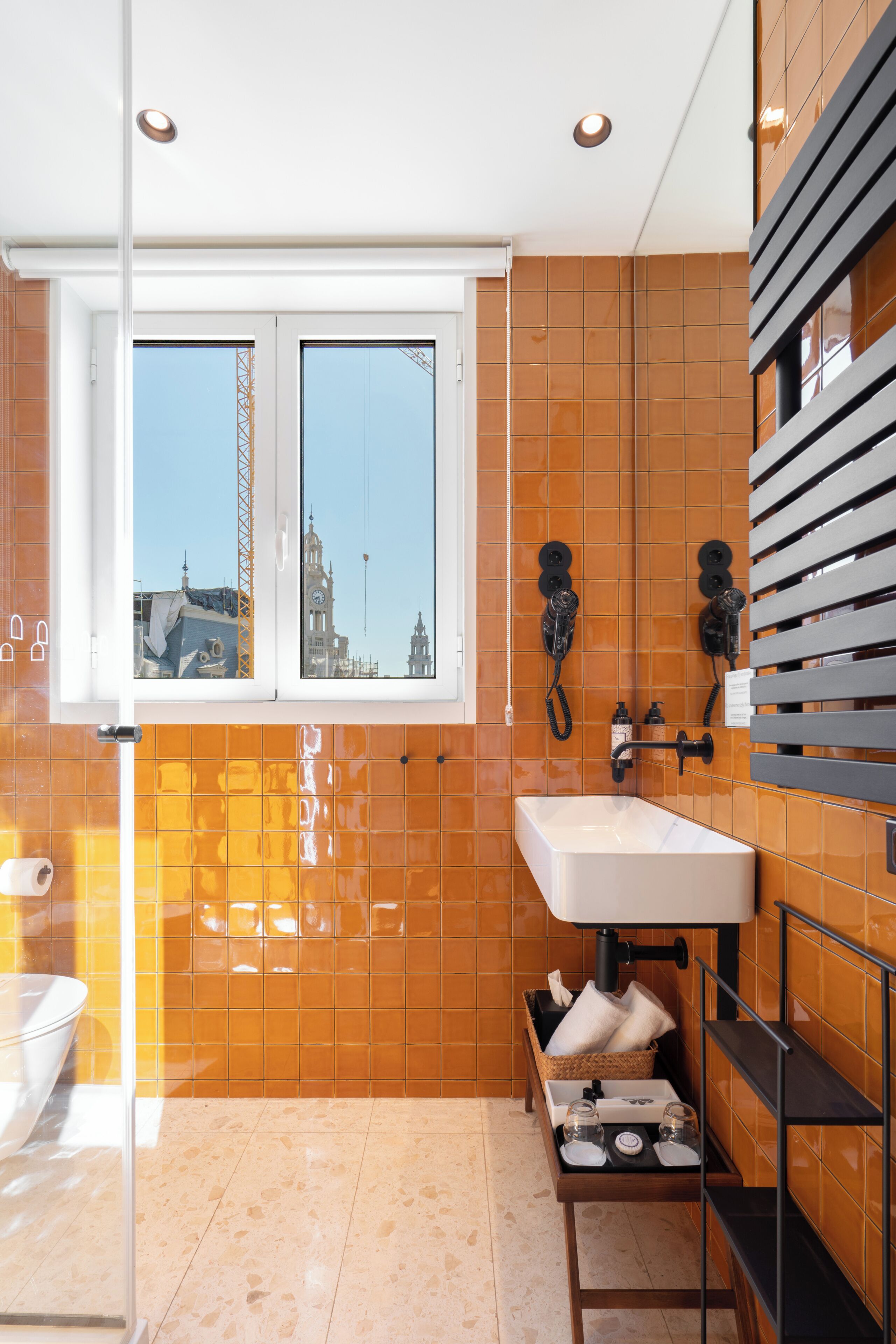 Une salle de bain avec une grande fenêtre, un lavabo et un miroir.