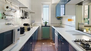 A modern kitchen with a microwave, stove, and various utensils.