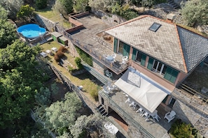 A two-story building with a swimming pool, outdoor seating, and a stone roof. - Villa 'Pia Recco' with Sea View, Private Pool and Wi-Fi (Recco)
