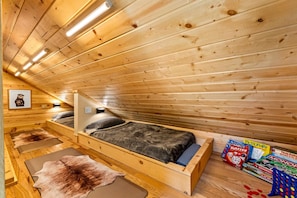 A wooden cabin interior with a bed, a game table, and a framed picture on the wall. - StoneHouse Suites | 4Bd/3Bth Home | Pet Friendly (Banner Elk)