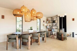 A modern dining area with a wooden table and chairs, a fireplace, and a bookshelf. - Villa LoKa - 5 bedrooms, swimming pool - Gulf of Saint-Tropez (Grimaud)