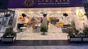A boutique hotel and restaurant named 'SIAM' with a modern facade, large windows, and a sign indicating a fusion of flavors and comforts. - Siam Boutique Hotel (Phayathai Road Bangkok)