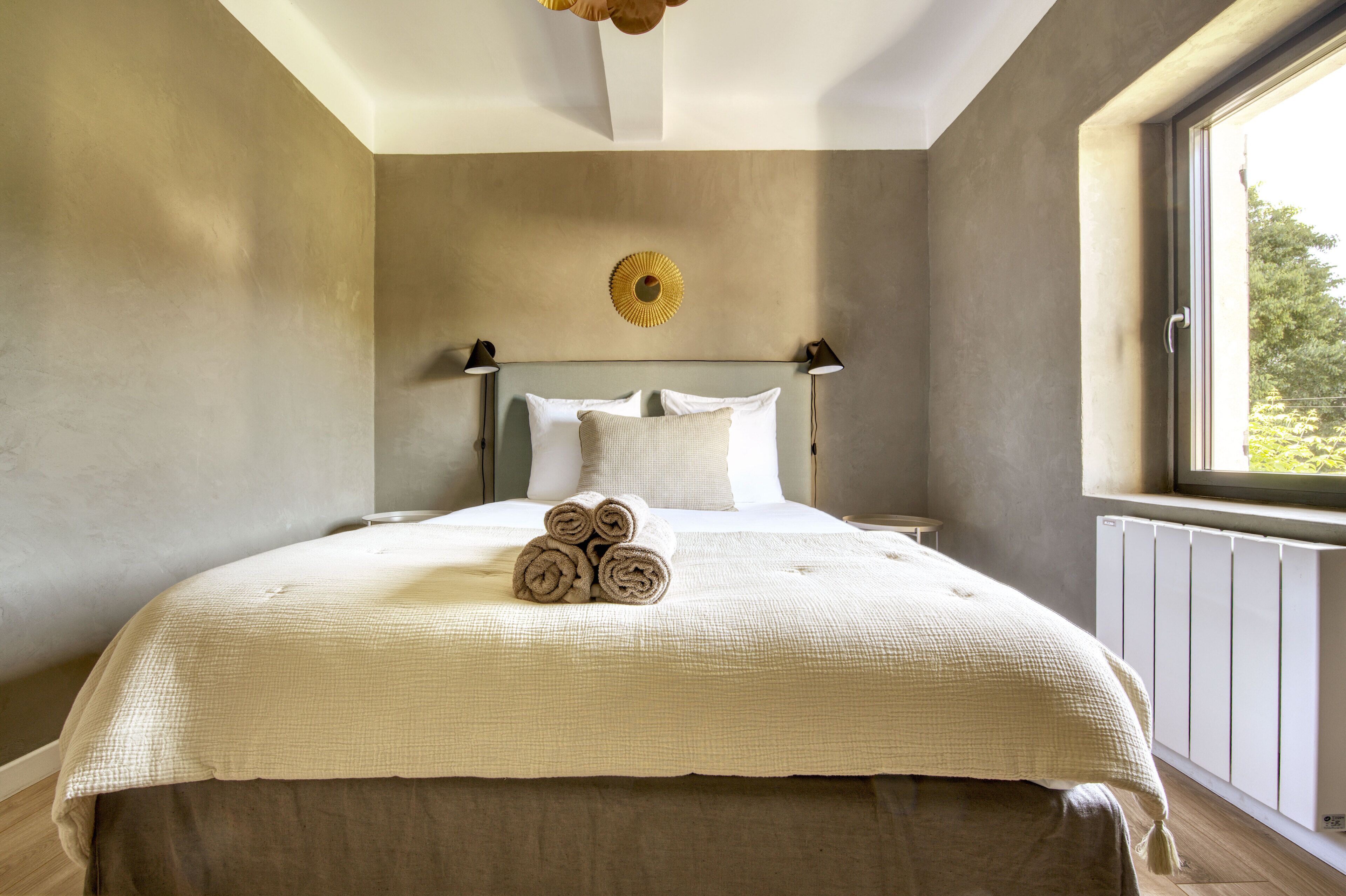 A bedroom with a bed, a window, and a radiator.