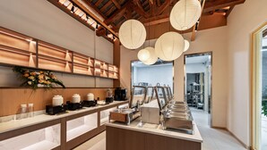 A buffet area with a wooden ceiling, hanging paper lanterns, and a flower arrangement on the wall. - APOLLO COURTYARD HOTEL (Zhangjiajie)