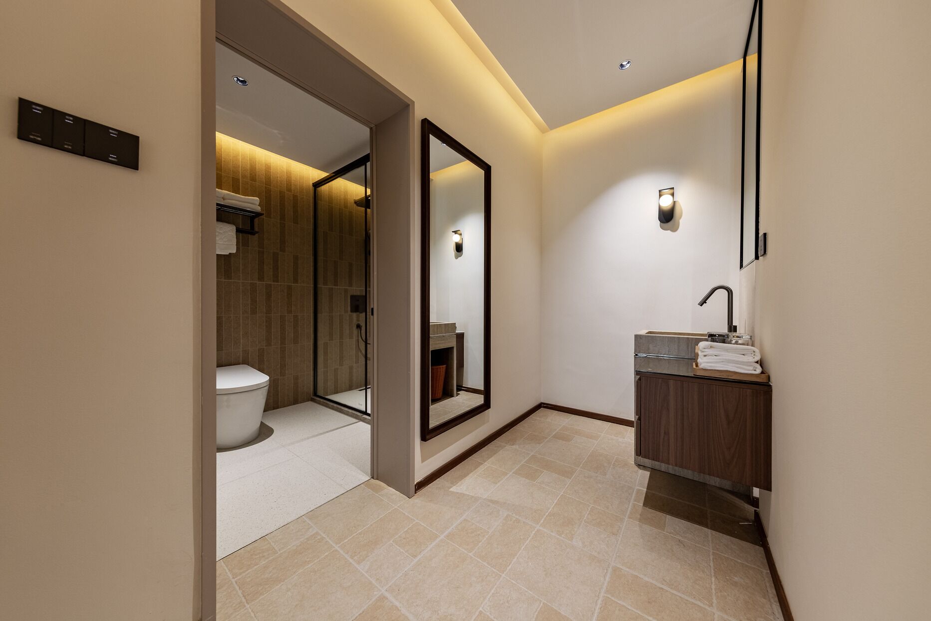 Une salle de bain moderne équipée de toilettes, d’une douche et d’un lavabo.