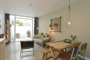 Zona pranzo con tavolo e sedie in legno, una panca e un lampadario a parete.