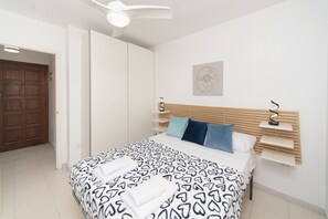A bedroom with a bed, a wooden headboard, a wall-mounted artwork, and a door. - WELCS APARTMENT 351 EMP with terrace (Rosas / Roses)