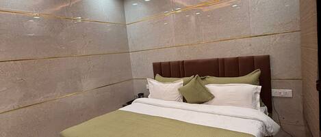 A modern bedroom with a bed, a ceiling fan, recessed lighting, and a marble floor.