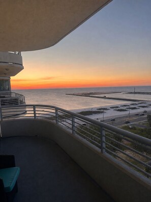 A balcony with a view of the sea at sunset. - Ocean Club. Gulf Views. Pool. Walk to Beach (Biloxi)