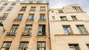 Un edificio de varios pisos con balcones, ventanas grandes y un estilo arquitectónico clásico.