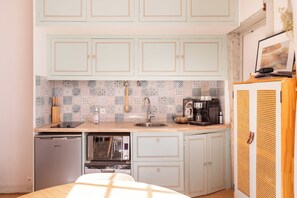 A compact kitchen with a dishwasher, microwave, and coffee machine. - Cozy Bright Studio for 2 Saint Germain des Pres (Paris)