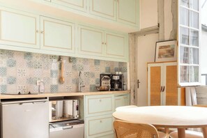A kitchen with patterned backsplash, a coffee machine, and a dishwasher. - Cozy Bright Studio for 2 Saint Germain des Pres (Paris)