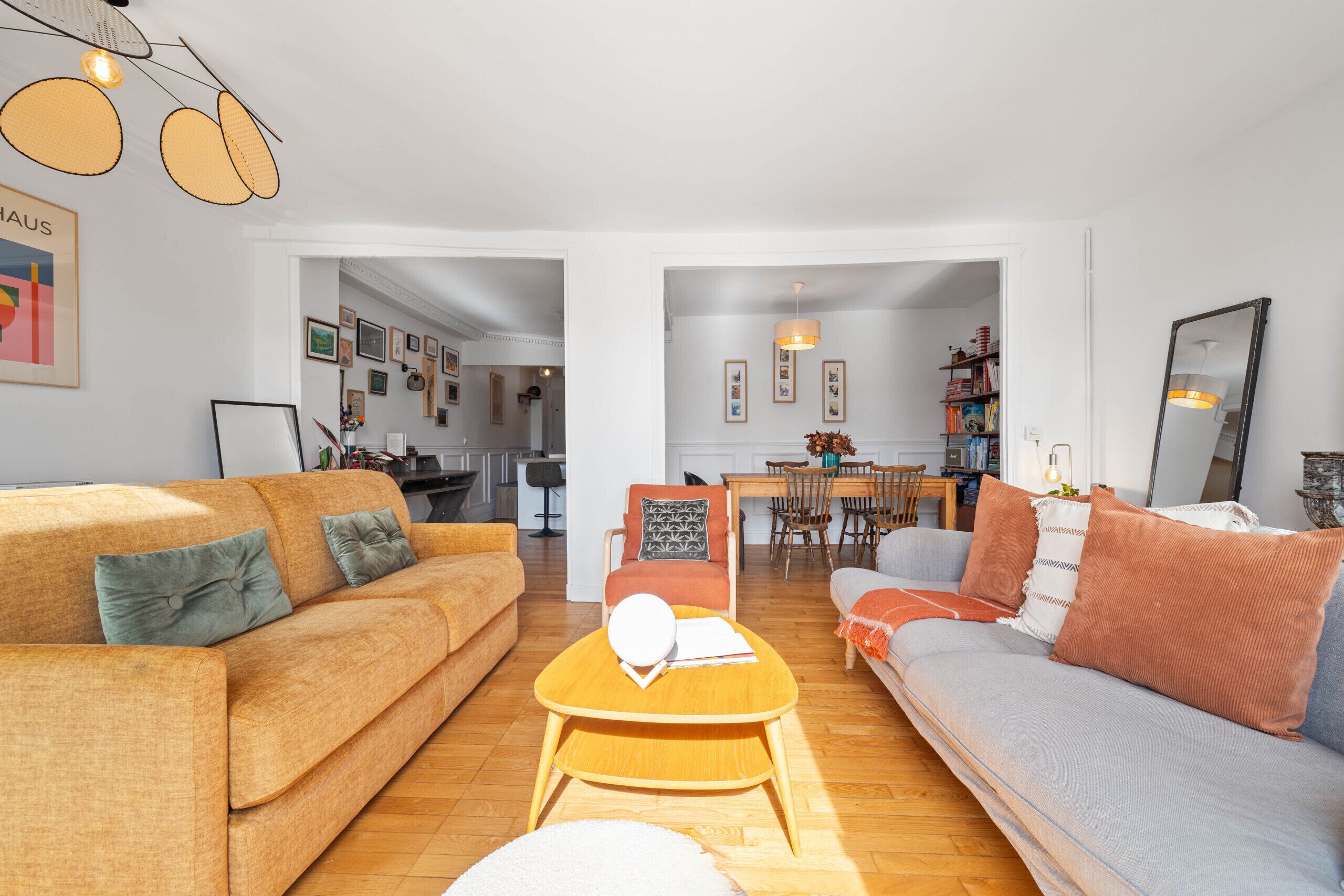 Una sala de estar con dos sofás, una mesa de centro y un comedor con sillas y una mesa.