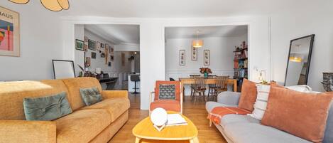 Una sala de estar con dos sofás, una mesa de centro y un comedor con sillas y una mesa.