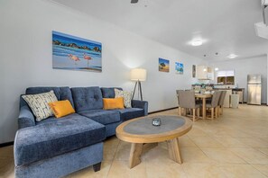 Ein Wohnzimmer mit einer Couch, einem Couchtisch und einem Essbereich mit Stühlen und einem Tisch.