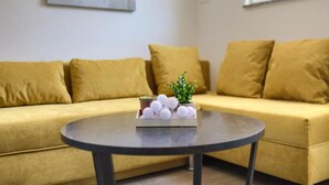 Ein Wohnzimmer mit einer Couch, einem Couchtisch und einer kleinen Pflanze.