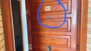 Uma porta de madeira com uma placa numerada '503' e uma fechadura.