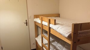 A bunk bed room with a wooden floor and a door. - 4 bed apartment - La Joue du Loup (Dévoluy)