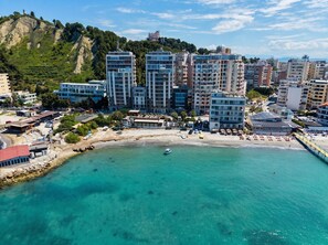 A coastal cityscape with modern buildings, a beach, and a mountain in the background. - Sea View Apartment In Durres with Private Parking (Durres)
