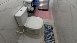 A bathroom with a toilet, sink, and shower.