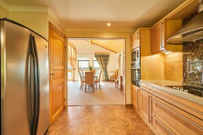 A kitchen with wooden cabinets, a stainless steel refrigerator, and a tiled backsplash.