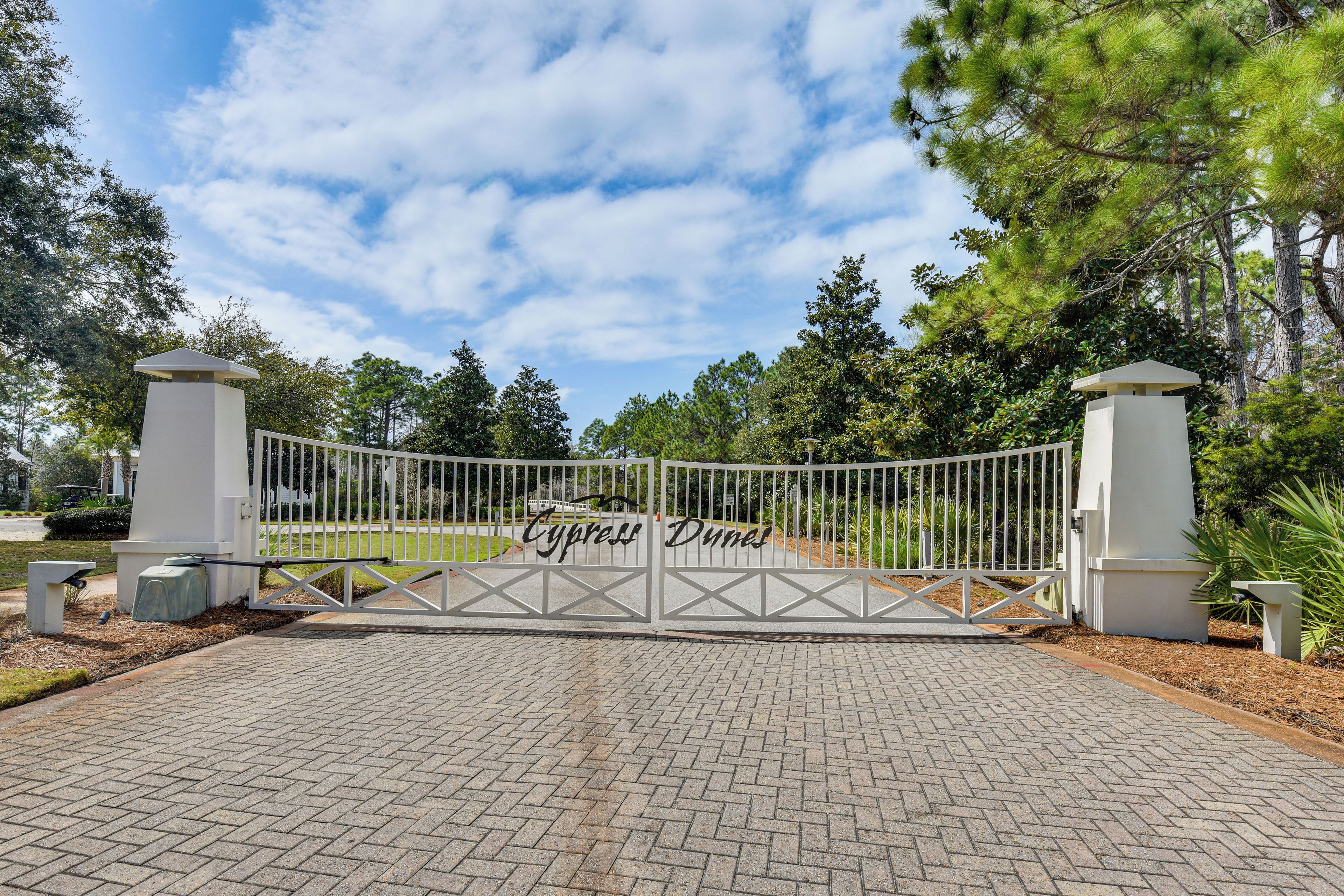 A gated entrance with a sign reading 'Cypress Dunes.'