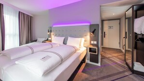 A hotel room with a large bed, bedside tables, a wardrobe, and a bathroom visible through an open door. - Premier Inn Frankfurt Eschborn (Eschborn)