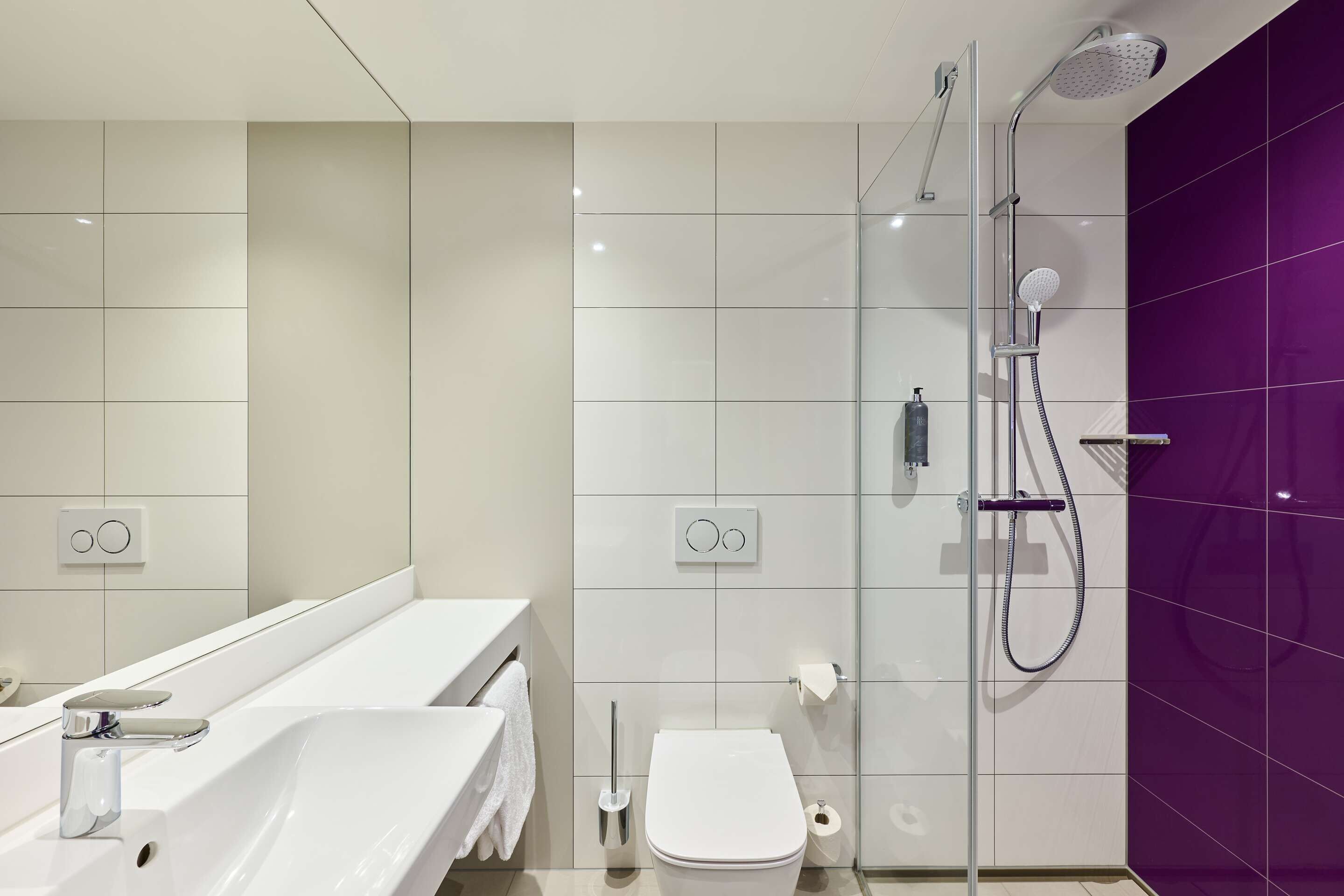 A modern bathroom with a bathtub, toilet, and sink.