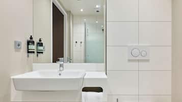 Un baño moderno con lavamanos doble, un espejo y un perchero para toallas.