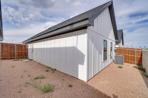 A modern building with a sloped roof, a gravel driveway, and a wooden fence.