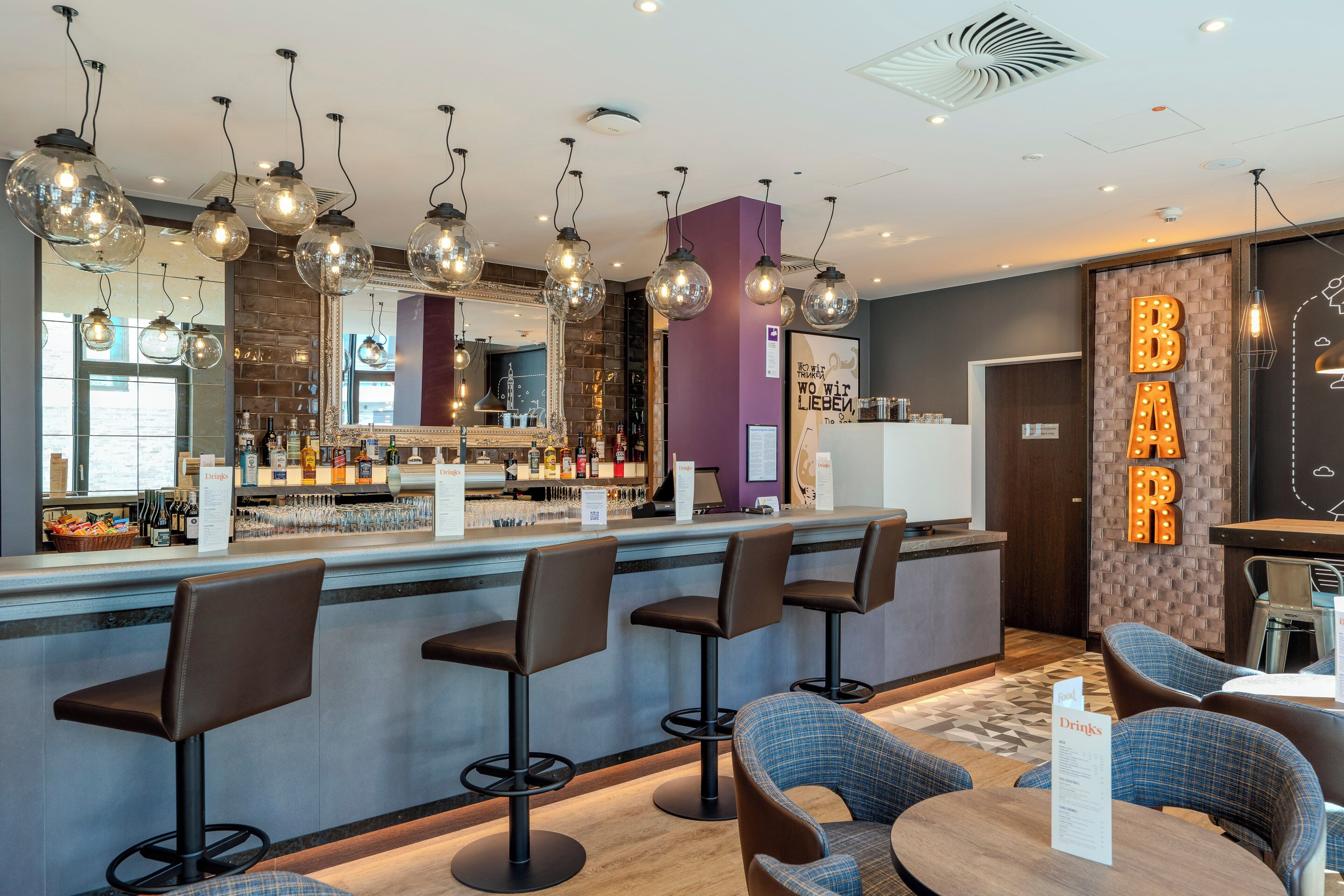A bar area with a counter, bar stools, and a sign that reads 'BAR'.